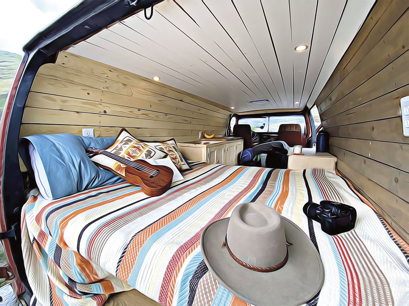 Inside of Dalton Russell's renovated van with bed, guitar, sink