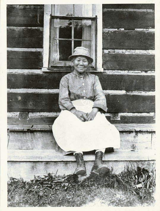 Polly Bemis sitting outside a cabin in Warren, Idaho