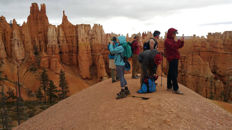 A tour group takes photos in Zion National Park