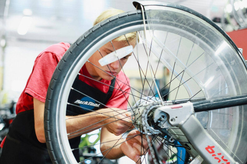 Young man repairs a bike
