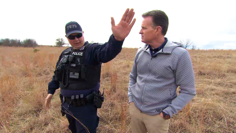 Police officer Matt Pearce in uniform in a grassy field with CBS news Doug Dunbar