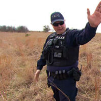Police officer Matt Pearce in uniform in a grassy field