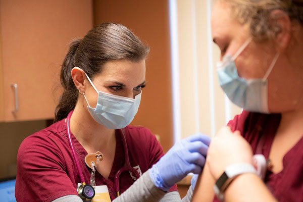 WSU Nursing student Leanne Nixon gives a COVID-19 vaccination
