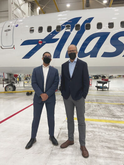 Cameron Limes and Lester Holt stand in front of an Alaska Airlines plane