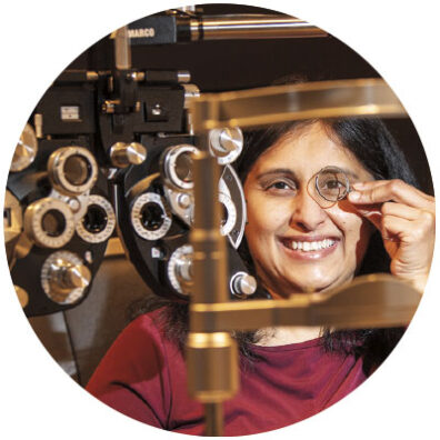 Rachna Narula, an optometrist at Washington State University Pullman, holds an eyesight measuring glass to her eye