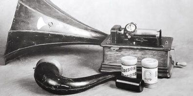 Black and white photo of an Edison phonograph with wax cylinders