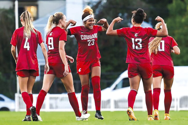 Washington State University soccer player Mykiaa Minniss grins and shows muscles at game