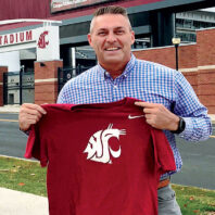 Gary Rubens holds up a Washington State University shirt in front of WSU Pullman's Martin Stadium