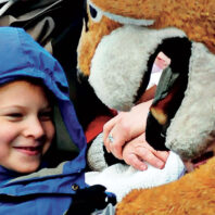 Washington State University mascot Butch Cougar greets a young boy in a winter coat