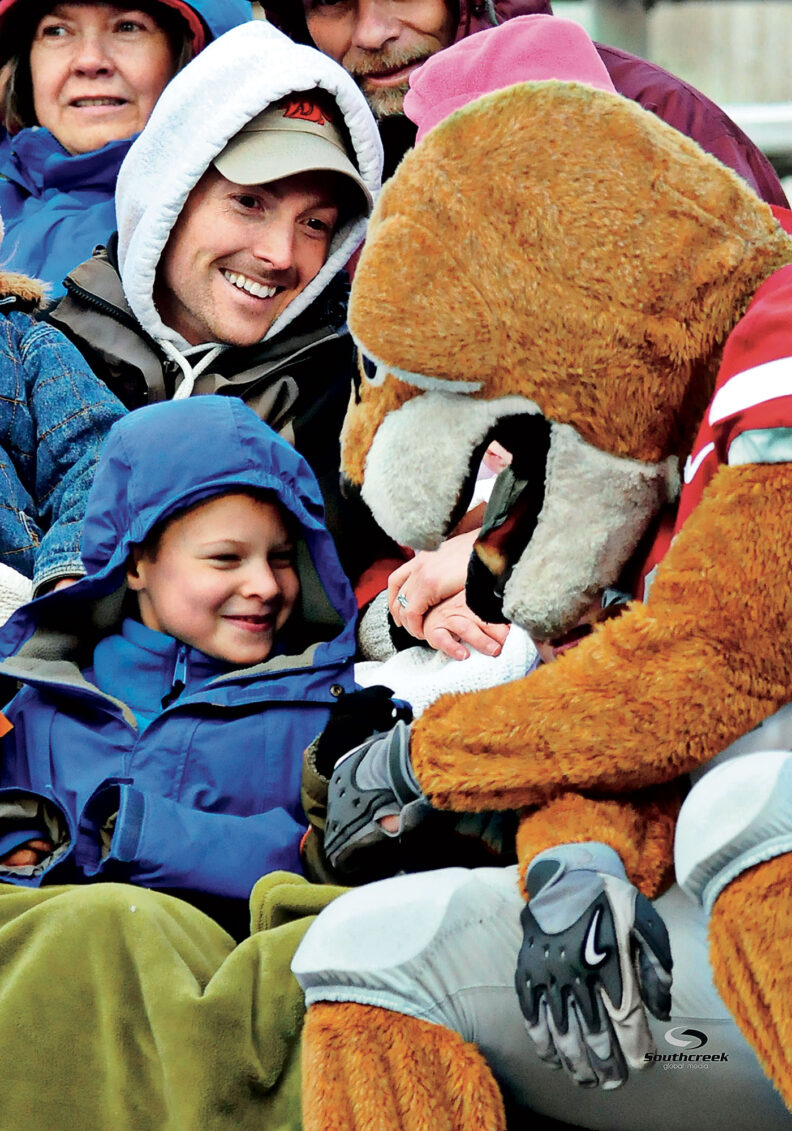 Washington State University mascot Butch Cougar greets a young boy