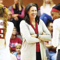 Washington State University head volleyball coach Jen Greeny laughs with her team's players