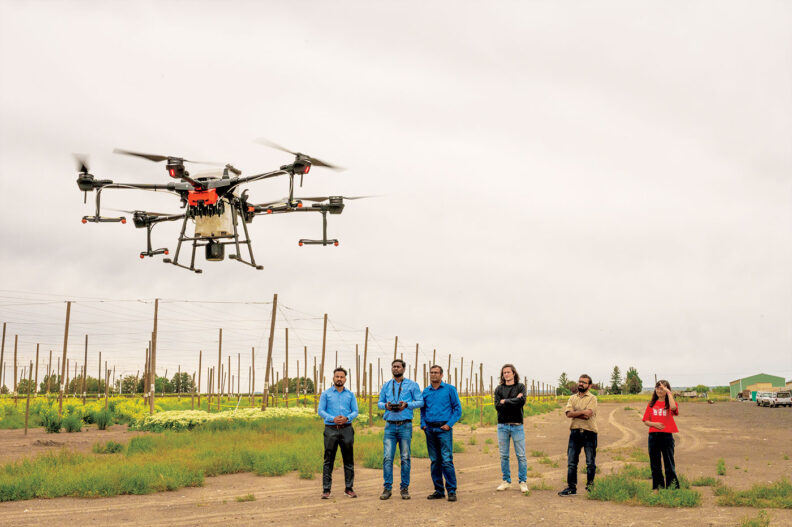 Drone hovers near orchards and hops fields in central Washington state while researchers watch and control flight