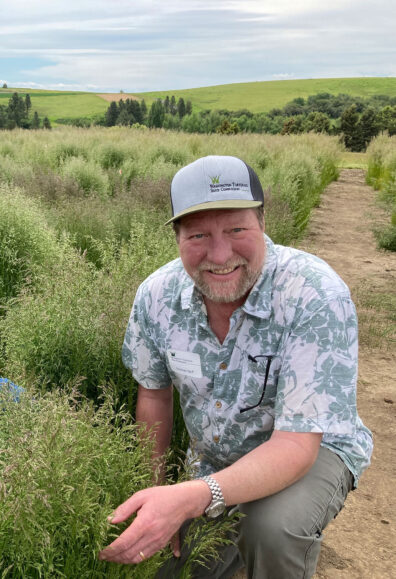 Michael Neff in a field examining grass