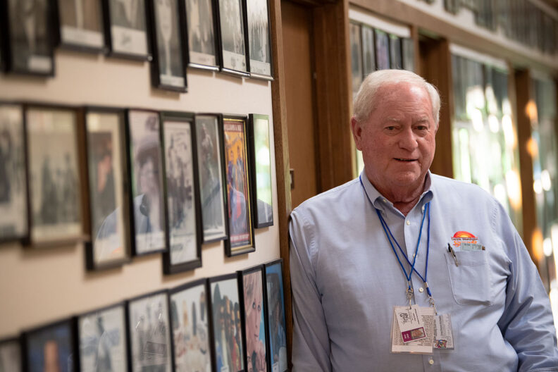 Greg Stewart next to photos from past fairs