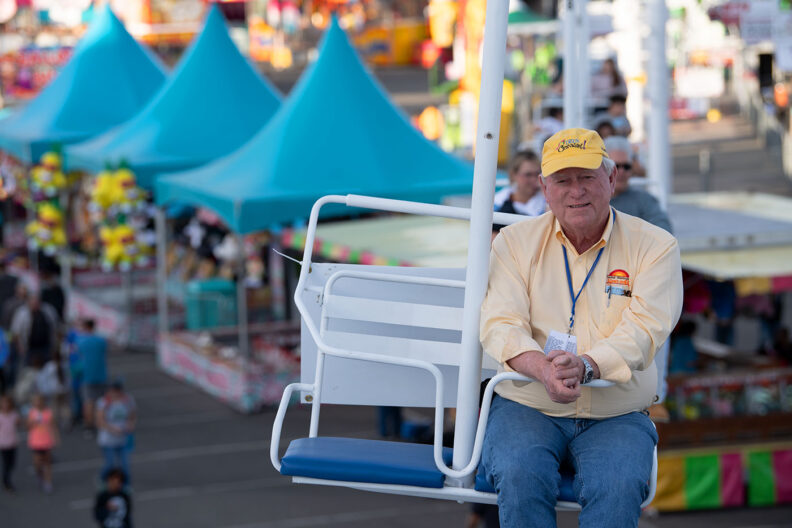 Greg Stewart riding a gondola at a fair