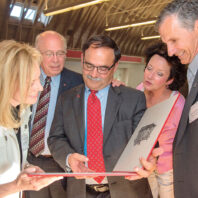 Daniel Bernardo looks at WSU Alumni Award certificate surrounded by others