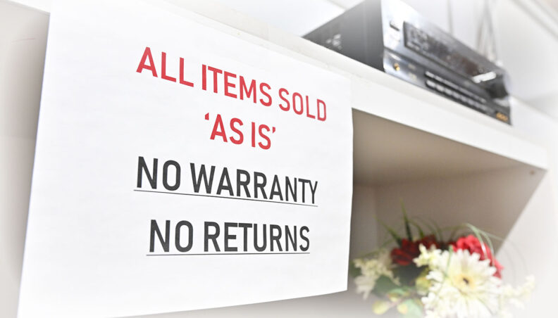 A sign at WSU Surplus that reads All Items Sold As Is, No Warranty, No Returns