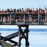 Kids at a camp in eastern Washington stand on a wooden bridge