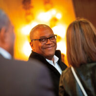 Ron Howell smiles at two people