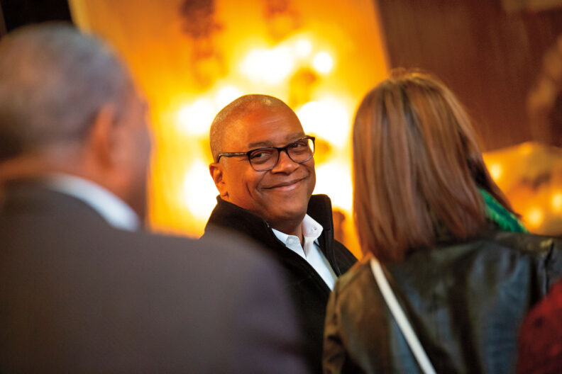 Ron Howell smiles at two people