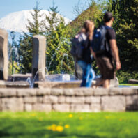 Two students walk in middle of WSU Vancouver with Mount St. Helens in the background