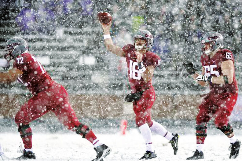 Quarterback Gardner Minshew about to release a pass at the 2018 Apple Cup. Snow blows around.
