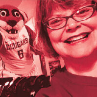 Sarah English close-up with photo of WSU mascot Butch behind her