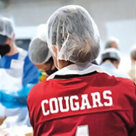 Back of person wearing a WSU Cougars jersey and hair net