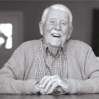 Smiling Dick Fry sits at a table for an interview.