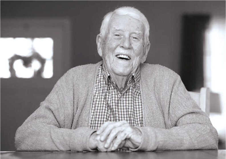 Smiling Dick Fry sits at a table for an interview.