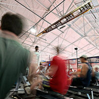 Remains of old WSU crew shell hangs above people working out on rowing machines