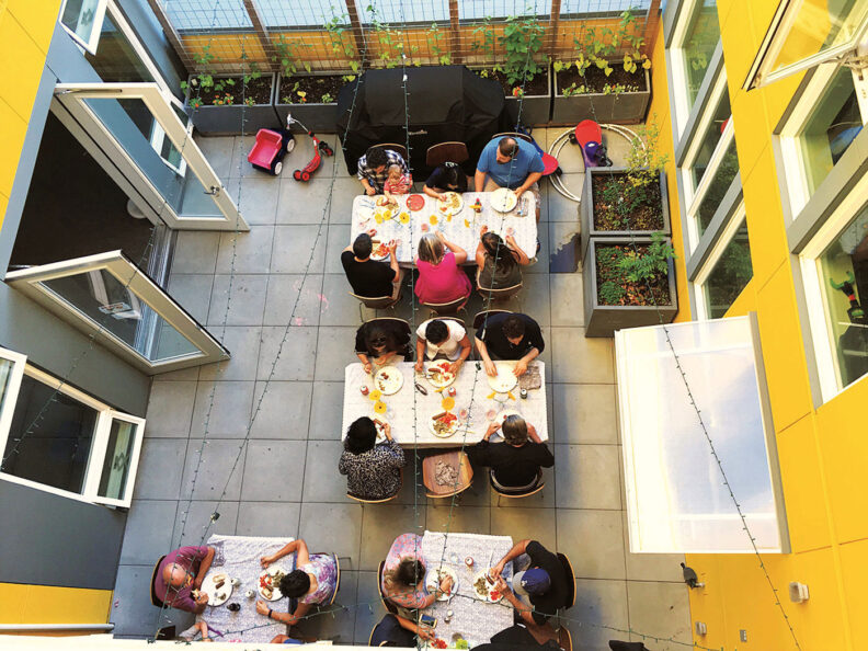 Looking down at people eating together in the courtyard at Capitol Hill Urban Cohousing in Seattle