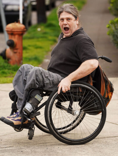 Tom Haig gives a surprised expression while rolling his wheelchair