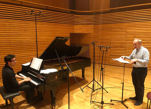 Eric McElroy at the piano and James Gilchrist preparing to sing in a sound studio