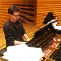 Eric McElroy plays piano in a studio