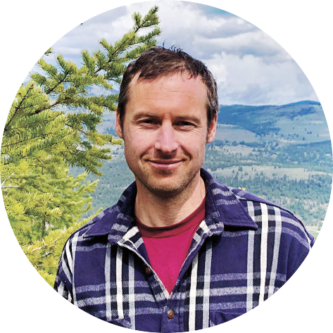 Robbie Andrus in front of tree and eastern Washington landscape