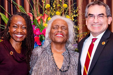 Judith Ray with a woman and man in front of bouquet