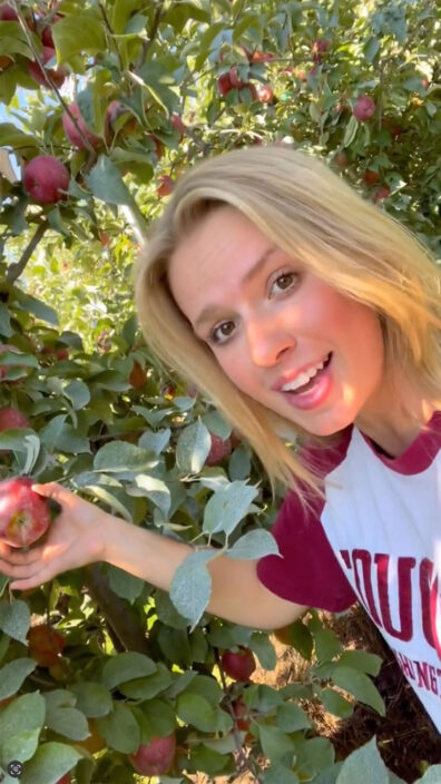 Kaitlyn Thornton shows an apple on the tree