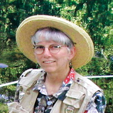 Headshot of Sharon Collman wearing a hat