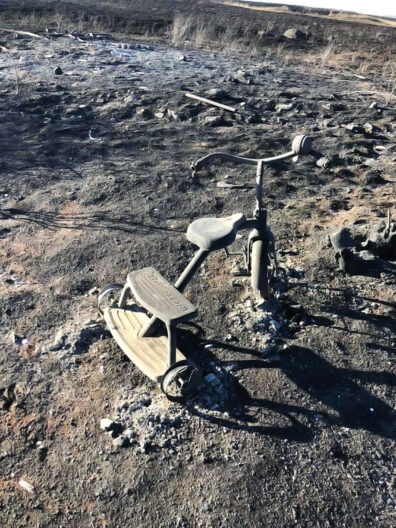 A tricycle in burned over lot