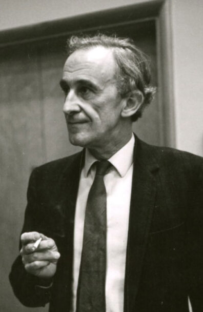 Alan Gabriel Barnsley in a suit and holding a cigarette