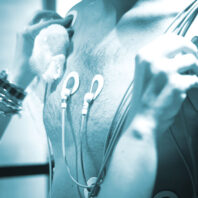 Blue tint photo of man having his heart rate and other vitals checked