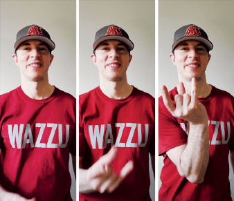 A man in a Washington State University hat and shirt holds up his hand in a W sign