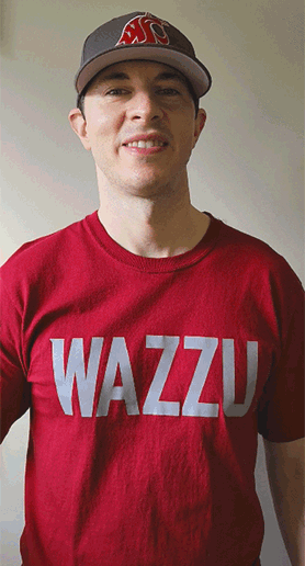 Man in WSU cap and shirt showing his WSU Cougar hand sign