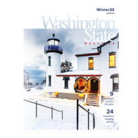 Cover of Washington State Magazine winter 2023 issue showing a lighthouse in snow with decorative lights