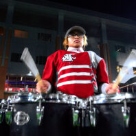 WSU Cougar Marching Band drummers playing at night for a football game