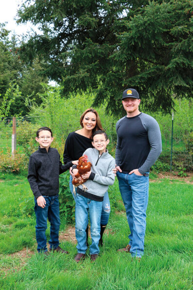 Man, woman and twin boys, one holding a chicken