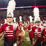 WSU Cougar Marching Band members marching on the football field