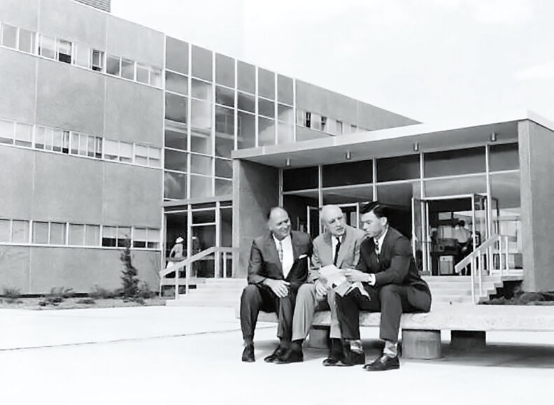 Black and white photo of three men in front of Johnson Hall at Washington State University