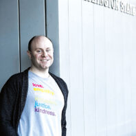 Michael Blankenship stands next to a WSU Vancouver building